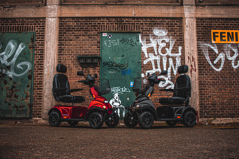 Mini Crosser Orange & Black together in front of urban graffiti wall