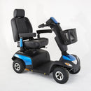 A black and blue electric mobility scooter with a high-back seat, armrests, a front basket, and four wheels, photographed on a seamless white studio background.