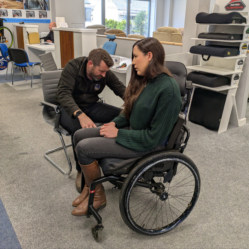 Tim our Product Specialist carrying out a wheelchair assessment with a female wheelchair user with Cerebral Palsy