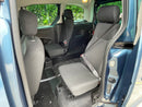 Interior of a wheelchair accessible vehicle with gray seats and open door showing greenery outside