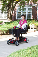A woman drives the Go-Go Elite Traveller Sport in the grounds of a house