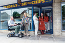 Man riding his Vierra LiFe Lithium Travel Scooter queuing for fish and chips